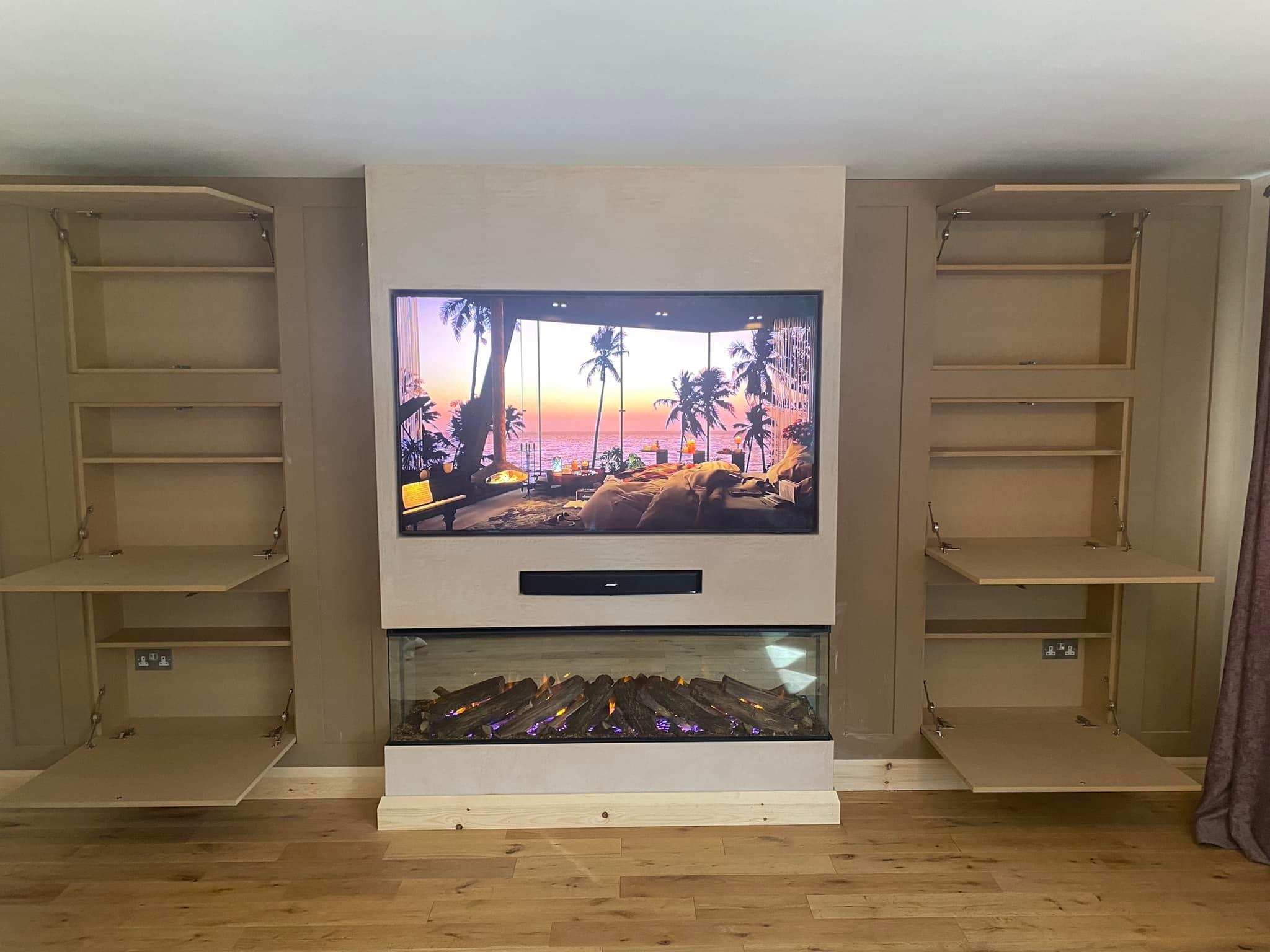 Media wall with fold-down cabinet doors either side of the TV and an inset fire